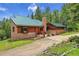 Charming exterior of a single-Gathering home with a brick chimney and a metal roof at 30122 Nancys Ln, Conifer, CO 80433