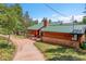 Charming exterior of a wooden home with brick accents, a green roof, and a well-maintained yard at 30122 Nancys Ln, Conifer, CO 80433