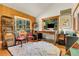 Bright home office featuring wood-paneled walls, bay windows with scenic views, and wood floors at 30122 Nancys Ln, Conifer, CO 80433