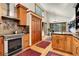 Spacious eat-in kitchen with wood cabinets, wood floors, large windows, and modern appliances at 30122 Nancys Ln, Conifer, CO 80433