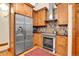 Well-organized kitchen featuring stainless steel appliances, wood cabinetry, and a colorful patterned rug at 30122 Nancys Ln, Conifer, CO 80433