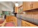 A bright kitchen with wood cabinets, a dark countertop and flooring, and stainless steel appliances at 30122 Nancys Ln, Conifer, CO 80433