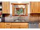 Close-up of a kitchen with wood cabinets, stainless steel appliances, and stone backsplash at 30122 Nancys Ln, Conifer, CO 80433