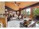 Spacious living room with vaulted wood ceilings, stone wall accent, and access to an outdoor deck at 30122 Nancys Ln, Conifer, CO 80433