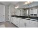 Bathroom with dual sinks, granite counters, white cabinets, and a tiled shower at 5271 Routt Ct, Arvada, CO 80002