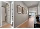 Long hallway with wood floors, multiple doorways, and stylish wall decor at 5271 Routt Ct, Arvada, CO 80002