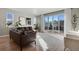 Bright living room features a leather sofa, light wood floors, and large sliding doors to the outdoor deck at 5271 Routt Ct, Arvada, CO 80002