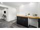Modern basement bar area with a wood countertop, black cabinets, and sleek fixtures at 6775 Newland St, Arvada, CO 80003