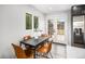 Bright dining area features a modern table and chairs, with natural light from the window and access to the outdoor deck at 6775 Newland St, Arvada, CO 80003