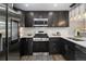 Modern kitchen featuring dark cabinets, stainless steel appliances, white countertops, and backsplash, and stylish pendant lights at 6775 Newland St, Arvada, CO 80003