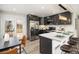 Stylish kitchen with stainless steel appliances, dark cabinetry, light countertops, and an eat-in bar area at 6775 Newland St, Arvada, CO 80003