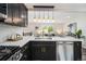 Open-concept kitchen with sleek appliances, dark cabinetry, light countertops, and bar seating, connecting seamlessly to the living area at 6775 Newland St, Arvada, CO 80003