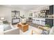 Open-concept living room and kitchen featuring modern design, stylish furniture, and stainless steel appliances at 6775 Newland St, Arvada, CO 80003