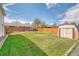 Large backyard with green lawn, wooden fence, storage shed, and mature trees at 9100 Yucca Way, Thornton, CO 80229