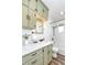 The renovated bathroom is complete with olive green cabinets, and subway tile tub at 9100 Yucca Way, Thornton, CO 80229