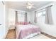 Cozy bedroom features two windows with beige curtains and a ceiling fan with lights at 9100 Yucca Way, Thornton, CO 80229