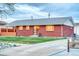 A well-maintained, single-story red brick home with a green lawn and concrete driveway at 9100 Yucca Way, Thornton, CO 80229