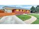 A well-maintained, single-story red brick home with a green lawn and concrete driveway at 9100 Yucca Way, Thornton, CO 80229