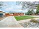 A charming brick home with a green lawn, concrete driveway, and covered parking at 9100 Yucca Way, Thornton, CO 80229