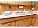 Close up of vintage basement kitchen featuring wood cabinets and pink countertops at 9100 Yucca Way, Thornton, CO 80229