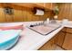 Close up of vintage basement kitchen featuring wood cabinets and pink laminate countertops at 9100 Yucca Way, Thornton, CO 80229