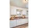 This kitchen features white cabinets, a stainless steel sink, a dishwasher, and hardwood flooring at 9100 Yucca Way, Thornton, CO 80229