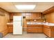 Basement kitchen with wood cabinets, a laminate counter, and a white refrigerator at 9100 Yucca Way, Thornton, CO 80229