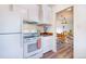 Well-lit kitchen with white appliances adjacent to dining area at 9100 Yucca Way, Thornton, CO 80229