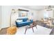 A stylish living room featuring a plush blue sofa, modern decor, and natural light at 9100 Yucca Way, Thornton, CO 80229