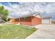 The back of the home showing the yard, driveway, and a detached garage at 9100 Yucca Way, Thornton, CO 80229