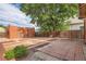 Landscaped backyard features brick patio, brick building, and mature trees at 827 S Sherman St, Denver, CO 80209