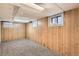 Finished basement with wood paneling, neutral carpet, and bright window light at 827 S Sherman St, Denver, CO 80209