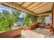 Inviting covered porch with brick detailing, climbing vines, and outdoor seating with neighborhood view at 827 S Sherman St, Denver, CO 80209