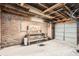 Exposed brick garage with beamed ceiling and workbench at 827 S Sherman St, Denver, CO 80209