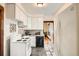 Bright kitchen with white cabinets, appliances, and views into the next room at 827 S Sherman St, Denver, CO 80209