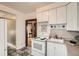 White kitchen featuring classic appliances, cabinets, and an open doorway into the next room at 827 S Sherman St, Denver, CO 80209