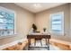 Office space featuring a wooden desk with metal legs, two windows, and decorative plants at 827 S Sherman St, Denver, CO 80209