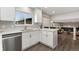 Bright kitchen with white cabinets, quartz countertops, and stainless steel dishwasher at 7391 S Marion St, Centennial, CO 80122