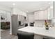 Modern kitchen features white cabinets, island seating, stainless steel appliances, and open floor plan at 7391 S Marion St, Centennial, CO 80122