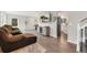 Open-concept living room with hardwood floors, a large TV, and view into the kitchen at 7391 S Marion St, Centennial, CO 80122