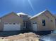 Tan home featuring a two car garage and a covered entrance on a sunny day at 901 Coal Bank Trl, Castle Rock, CO 80104