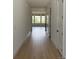 Bright hallway featuring gleaming hardwood floors and white walls, with a view to a sunlit living space at 901 Coal Bank Trl, Castle Rock, CO 80104
