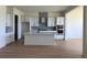 Well-lit kitchen featuring white cabinets, stainless steel appliances, hardwood floors and a spacious kitchen island at 901 Coal Bank Trl, Castle Rock, CO 80104