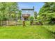 View of fenced backyard with wooden gate, luscious green grass and home's deck at 11404 W Sharkstooth Peak, Littleton, CO 80127
