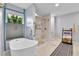 Modern bathroom featuring a soaking tub, glass-enclosed shower, and natural light at 11404 W Sharkstooth Peak, Littleton, CO 80127
