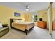 Cozy bedroom with warm yellow walls, comfortable bed, and ample natural light at 11404 W Sharkstooth Peak, Littleton, CO 80127