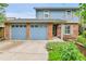 Charming blue two-story home with a brick facade and a two car garage at 11404 W Sharkstooth Peak, Littleton, CO 80127
