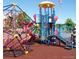 Community playground with colorful climbing structures, slide, and overhead protection on a rubber surface at 11404 W Sharkstooth Peak, Littleton, CO 80127