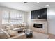 Cozy living room with stone fireplace, plush seating, and natural light at 8271 Bluebell Way, Denver, CO 80221