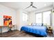 Bright bedroom features stylish ceiling fan, wood floors, desk, and vibrant modern art at 1323 Elati St # 3, Denver, CO 80204